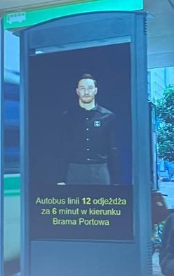 Avatar postaci ludzkiej wyświetlony wraz z tekstem na ekranie na przystanku autobusowym. Forum Dostępności w Transporcie