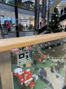 widoczny na barierce kod NaviWay, nalepka przyklejona koło schodów ruchomych, w tle choinka